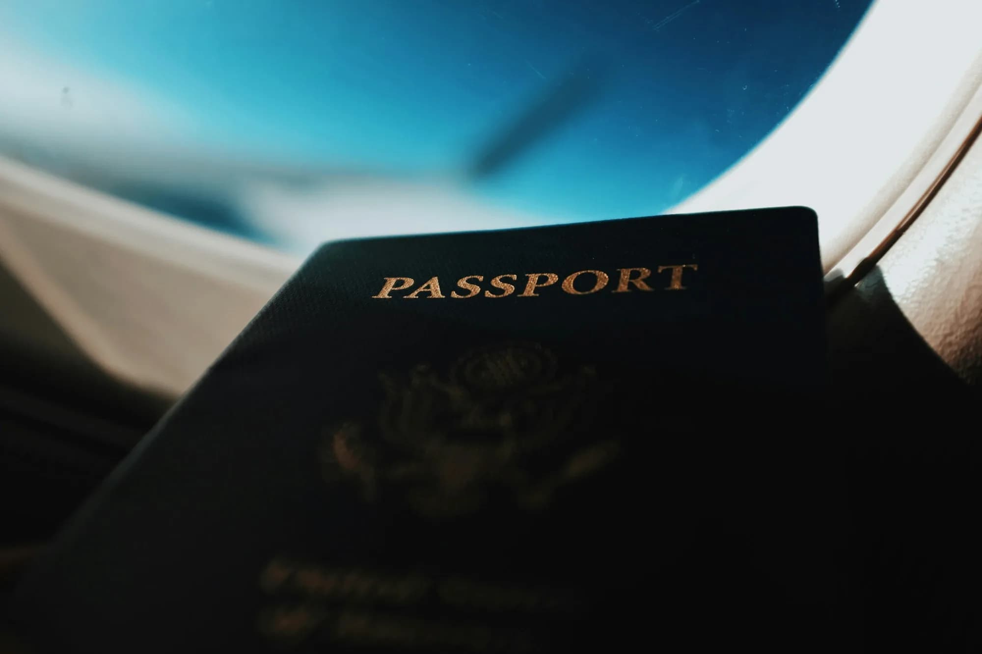 Паспорт біля ілюмінатора літака на заході сонця — імміграційний кейс LegalWin